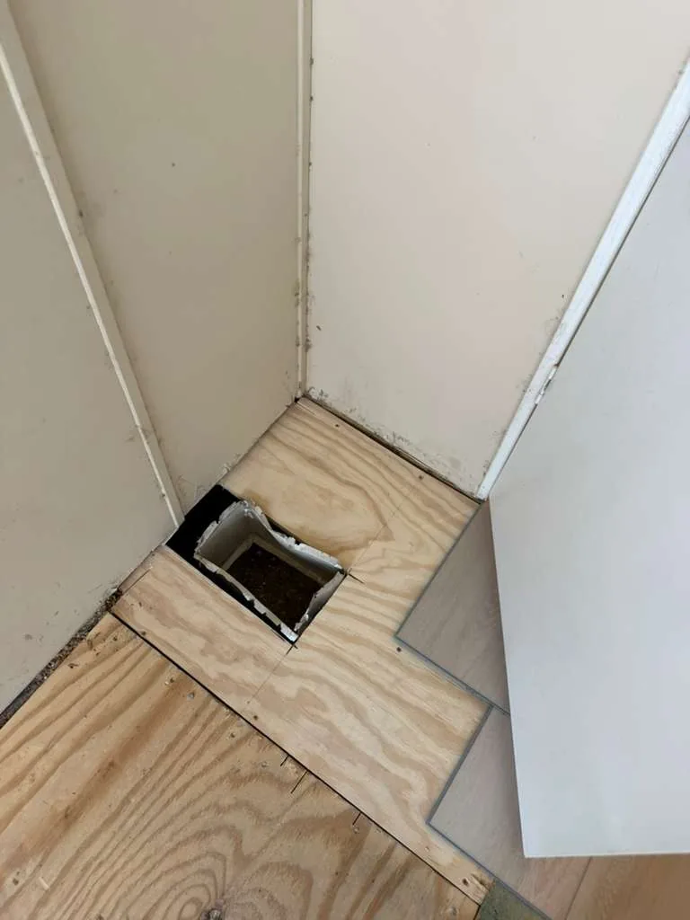 New plywood subfloor installed at a hallway corner in Winter Garden