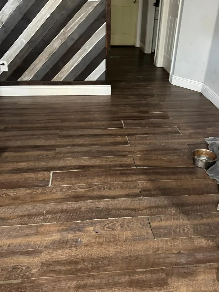 Luxury vinyl plank flooring with visible joint separation and lifting in a hallway