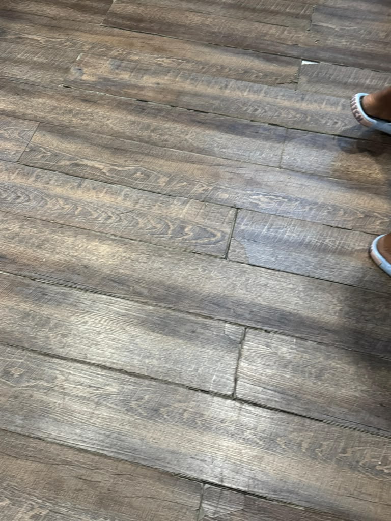 Close-up of separated and lifted vinyl plank flooring joints